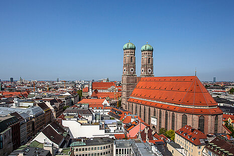Das Foto zeigt die Münchner Skyline mit der Frauenkirche rechts im Bild