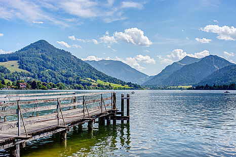 Das Foto zeigt den Schliersee und einen Holzsteg