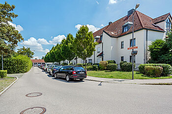 Zu sehen ist eine Straße mit Wohnhäusern und geparkten Autos in Dachau 