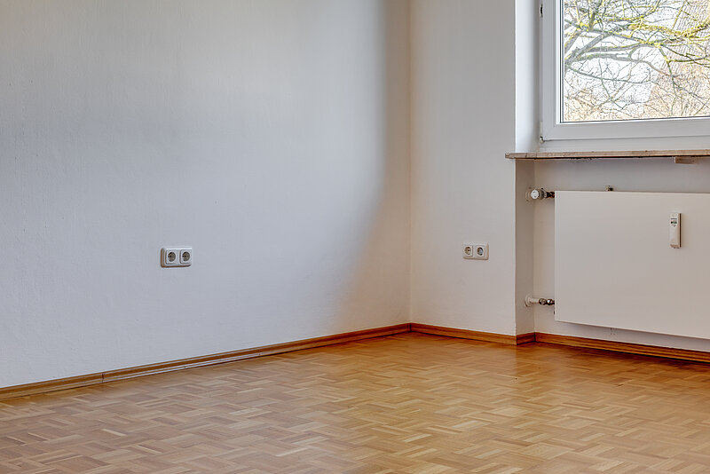Zimmer vorher Zu sehen ist ein leeres Zimmer mit Fenster und Heizung.