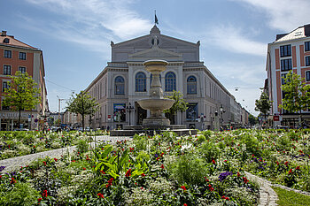 Zu sehen ist der begrünte Gärtnerplatz mit Brunnen