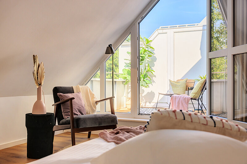 Nachher: dasselbe Dachgeschosszimmer nach dem Home Staging mit Sessel, Bett, Deko und möblierter Decke