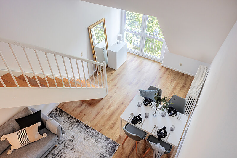 Nachher: derselbe Wohnraum nach dem Home Staging mit Sofa, Teppich und gedecktem Esstisch