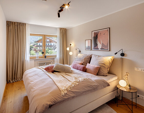 Schlafzimmer mit Doppelbett, Nachttischen und Leseleuchten