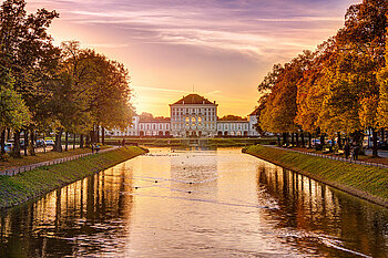 Zu sehen ist das Schloss Nymphenburg in Neuhausen bei Sonnenuntergang