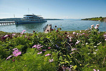 Zu sehen ist der Starnberger See mit einem Schiff im Hintergrund