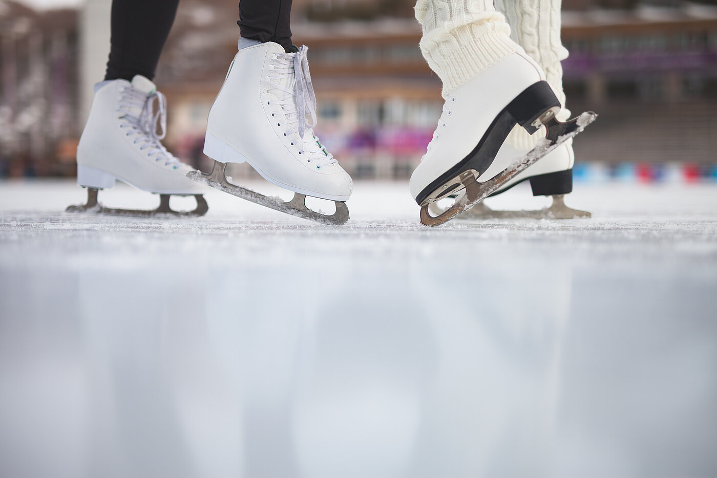 Schlittschuhlaufen Zu sehen sind zwei Personen in Schlittschuhen auf dem Eis.