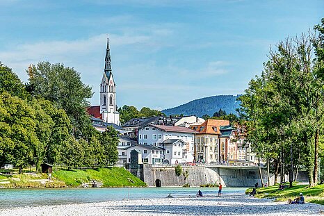 Zu sehen ist ein Fluss und Kiesstrand mit Blick auf Bad Tölz