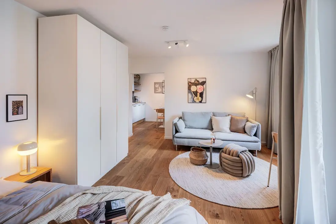 Möbliertes Apartment mit Bett, Sofa und Küche in einem Raum