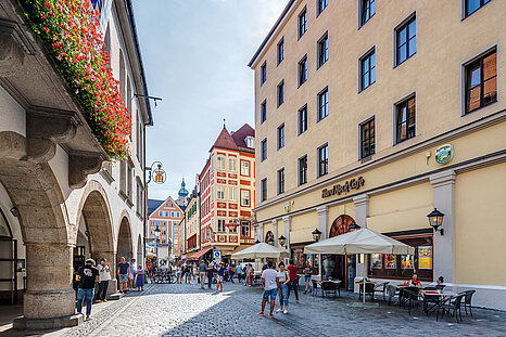 Das Foto zeigt eine Straße mit Kopfsteinpflaster in der Münchner Altstadt bei sonnigem Wetter
